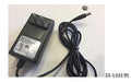Black AC power charger with plug and cord on white surface