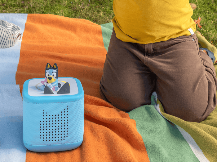 child playing with Toniebox 2, an audio player for kids with Bluey audio figurine