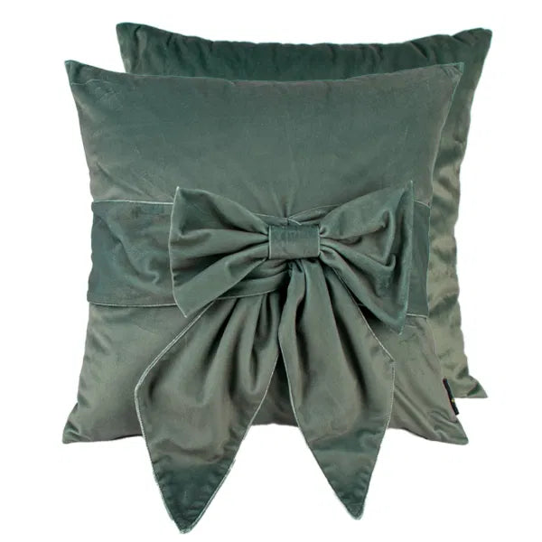Two green pillows with a large bow on a white background