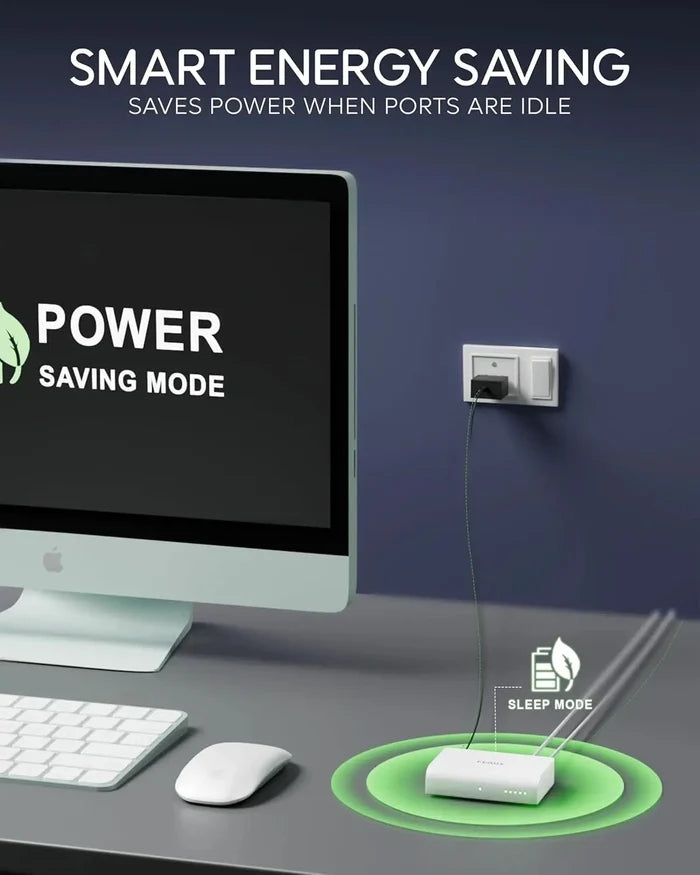 Computer setup with power saving mode display and smart energy saving device on a desk.