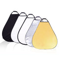 A set of triangle-shaped photography reflectors in gold, silver, white, black, and translucent colors, displayed in a row with a carrying case.