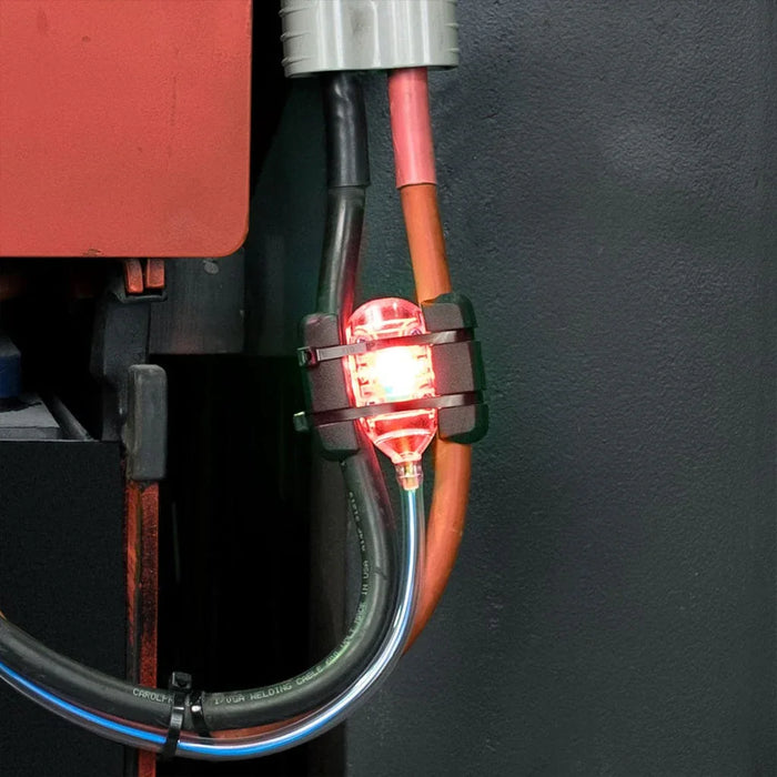 Battery monitoring device with red LED indicator installed on industrial power cables