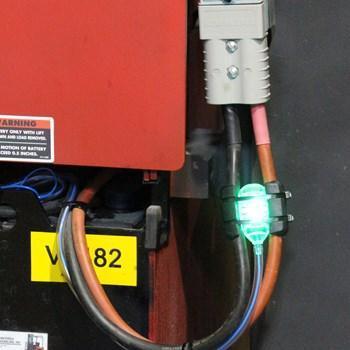 Smart Blinky Pro battery monitor with green indicator light attached to industrial power cables
