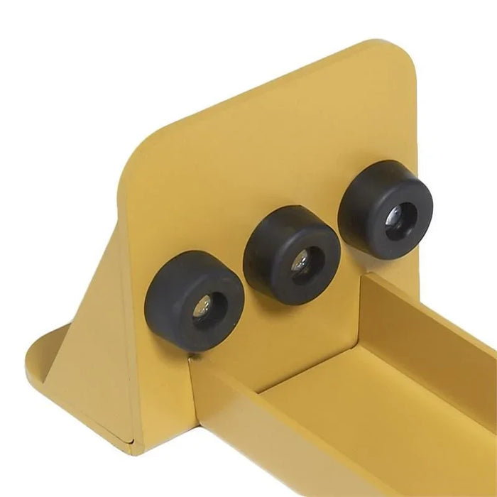 Yellow metal track end stop with three black rubber bumpers for industrial use